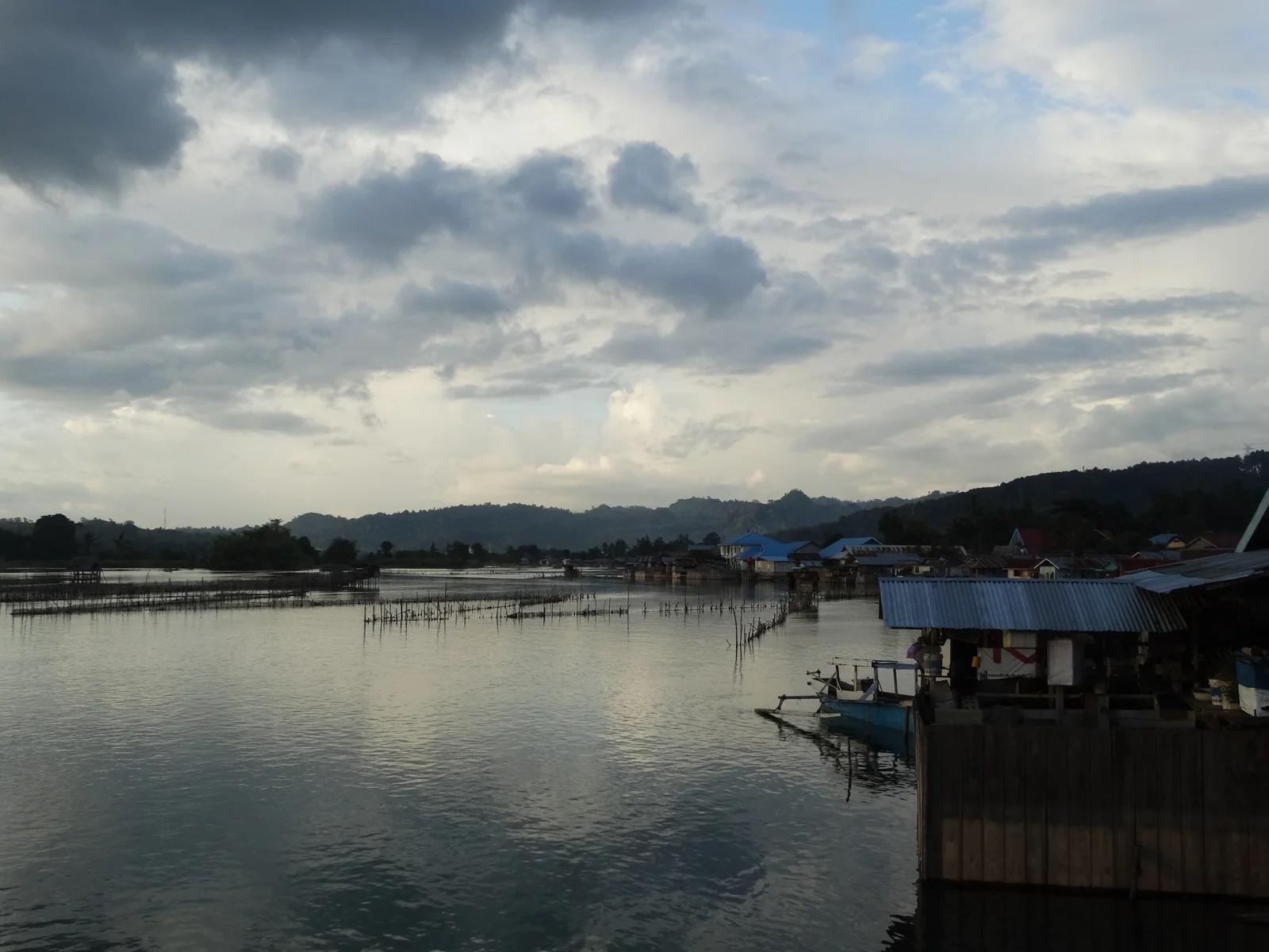 Danau Poso di Tentena, Sulawesi Tengah, dengan perbukitan di kejauhan.